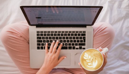 Hands on a computer with latte