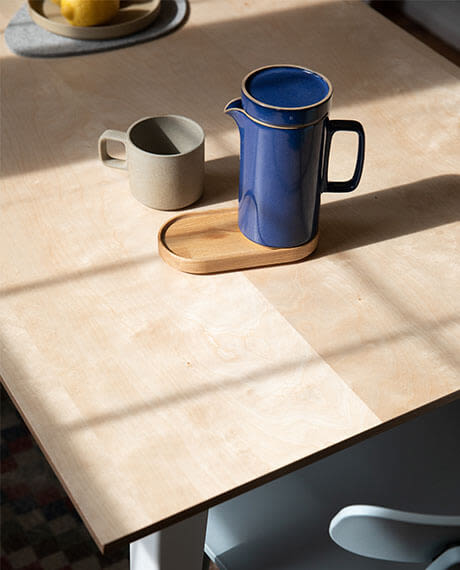 A pitcher and a cup on the Birch Floyd Rectangular Table.