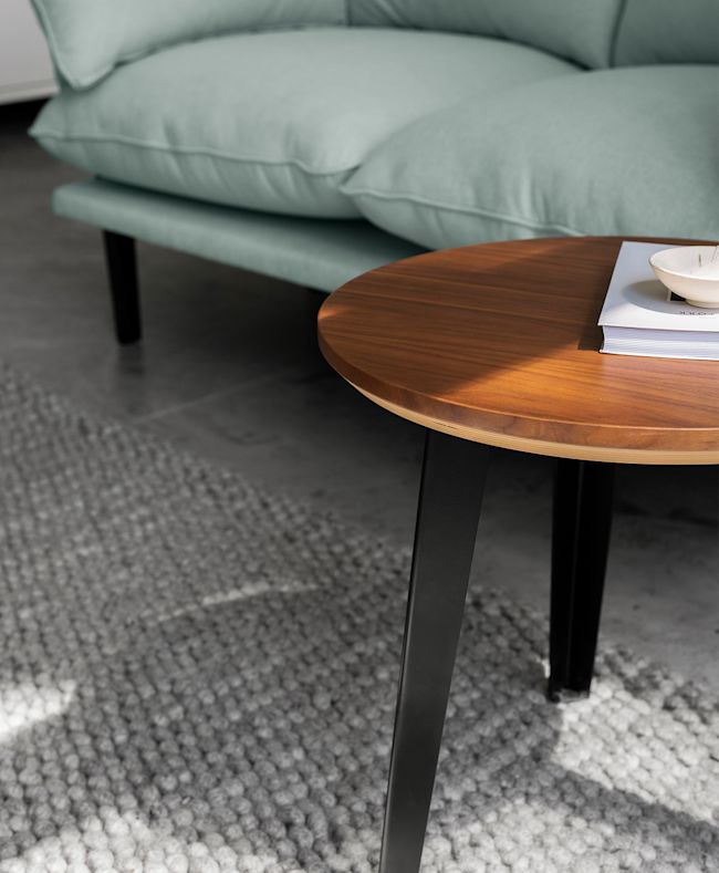 The Floyd Side Table in Walnut with Black legs sits in front of a Floyd Sofa.