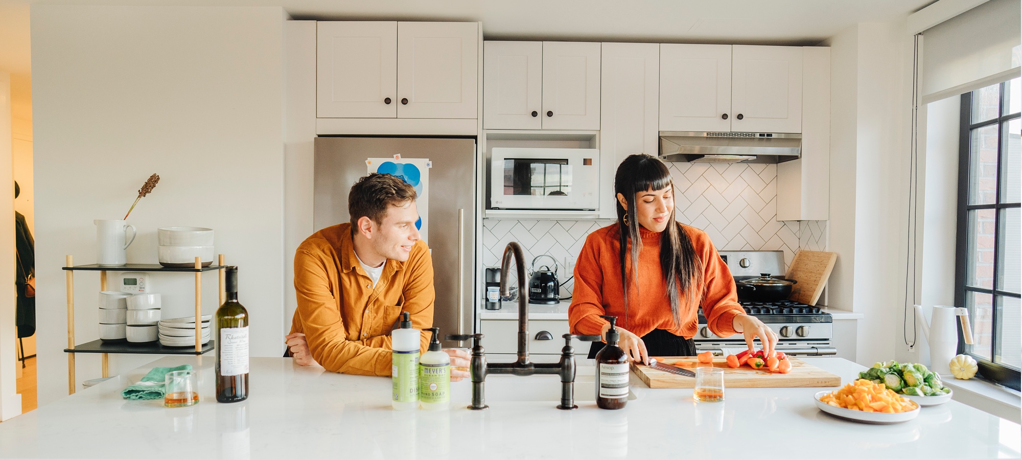 A photo of Brooklyn based couple Liron and Gal in their clean, well finished kitchen. Read more about them on the Floyd Blog, LivedIn.