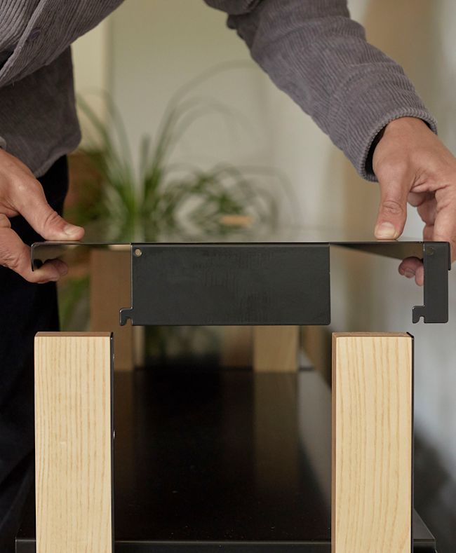 The top shelf of the Media Console shown being inserted into the wood supports.