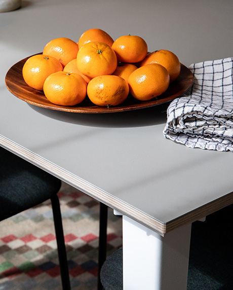 Corner shot of a small plate of oranges on a fog table.