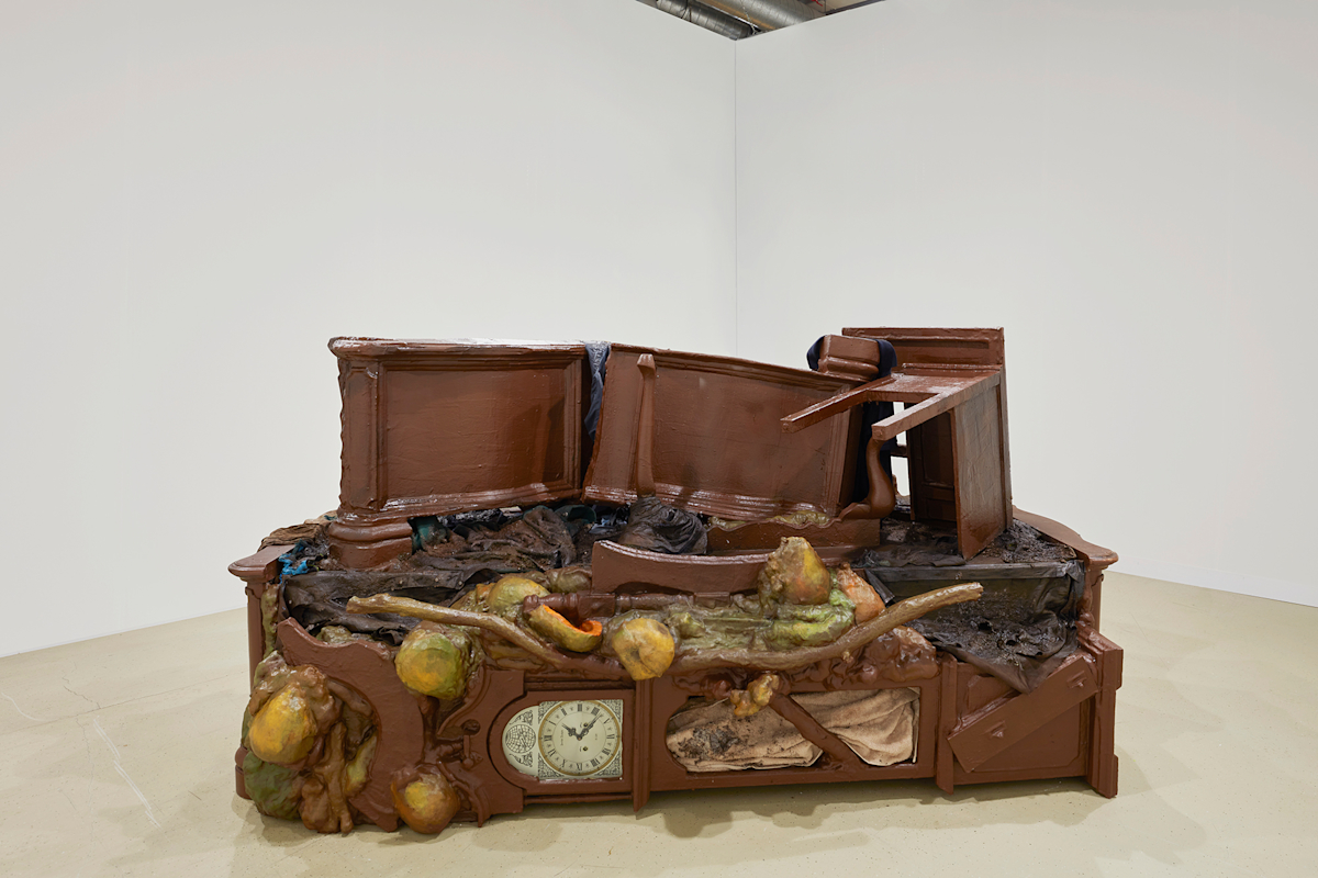 A large piece of brown furniture sits in the middle of a room with white walls.