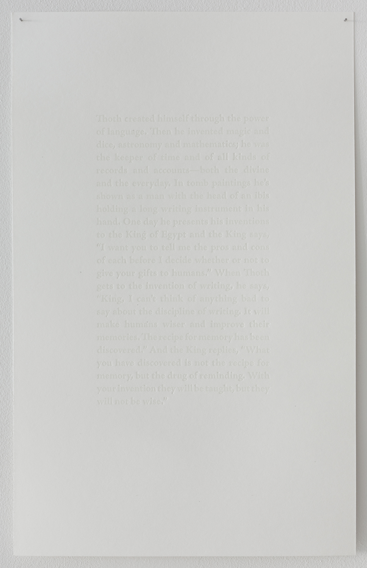 Image of a white sheet of thick paper, printed with letterpress type with no ink so it is quite hard to read the text which is just the embossed shape of letters with no color.