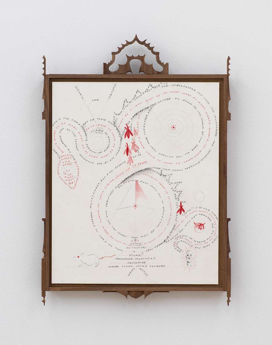 Image of Harry Gould Harvey IV drawing framed in foraged walnut wood, depicting lines of text forming an image of a coiled snake, including depictions leaves, with decorative pieces of carved walnut attached to the top and bottom of the frame.