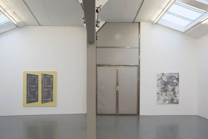 Installation view of two paintings by Viktor Kopp. The painting on the left has a yellow background with two floating doors painted at the center of the canvas. The painting on the right is black and white with abstract and gestural brush marks.