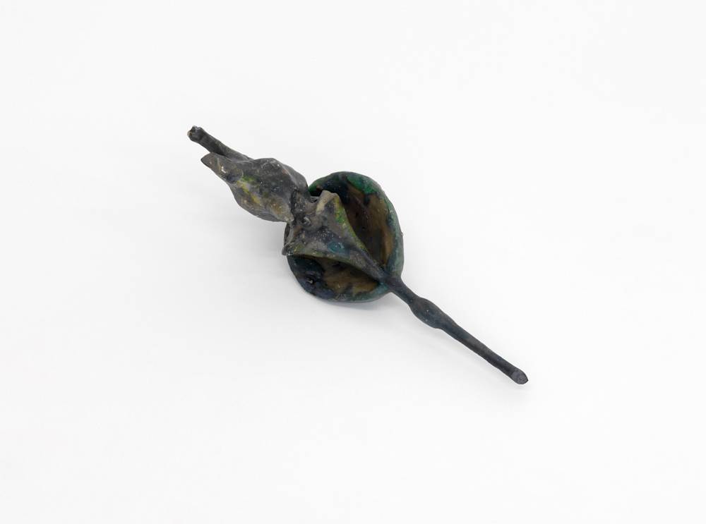 A small abstract sculpture resembling organic material . It is gray.