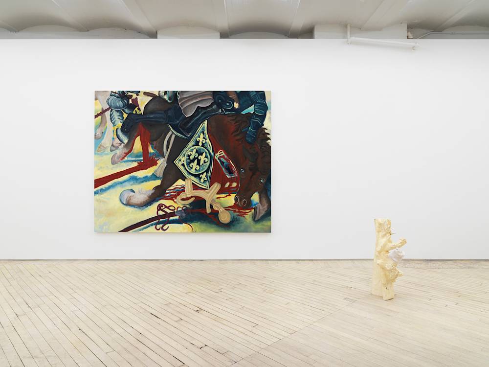 In a gallery space, a large painting is hung on a white wall depicting an abstracted scene of a cartoon-like horse collapsing in a battle field. To the right on the floor is abstract sculpture with a light-than finish. One of the protrusions coming out of the main form has a sock hanging over it.
