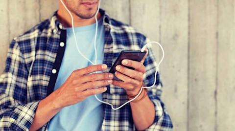 Guy with earphones listening on iPhone