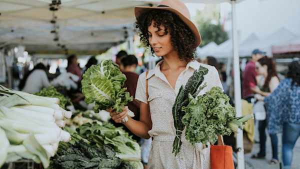 Beautiful woman buying kale at a farmers market Beautiful woman buying kale at a farmers market