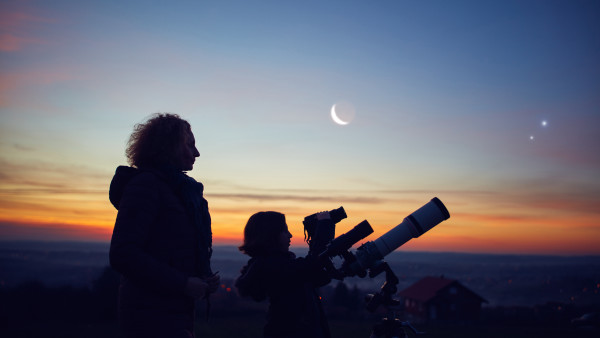 Mère et fille observant les étoiles, les planètes, le ciel de la Lune et le ciel nocturne avec un télescope astronomique.