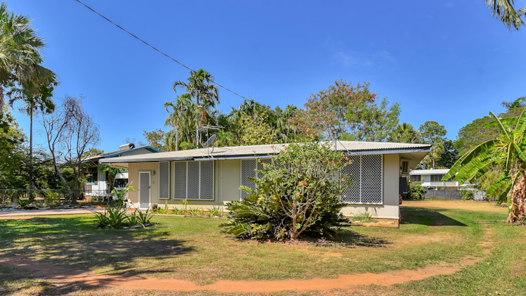 Outside of home with grass, trees and a one story home.