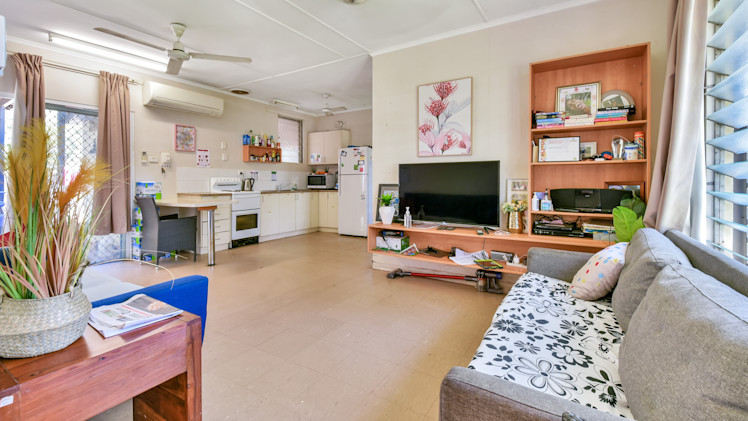 Living room, tiled floor, two couches, TV.