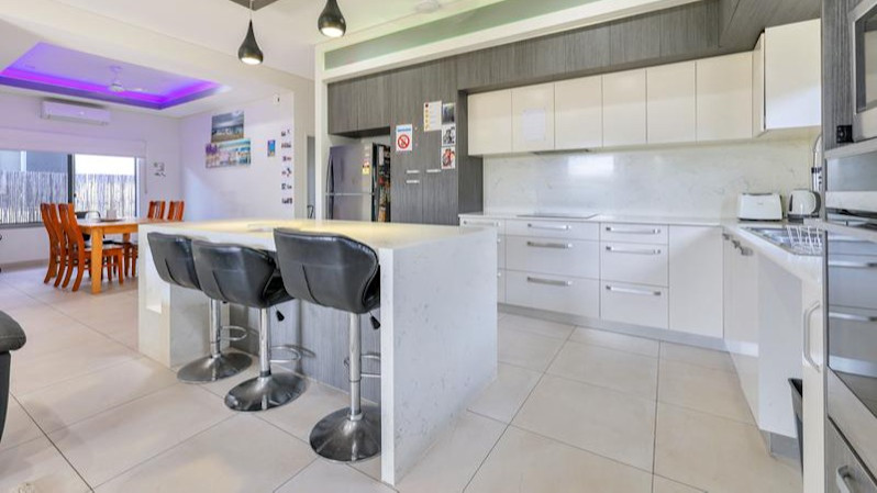 Kitchen with island bench, bar stools, white finishing's.