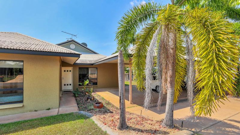 Front of home with palm trees, yellow exterior.