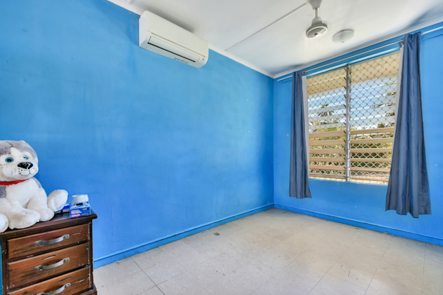 Bedroom with bright blue walls, tile floor, large window.