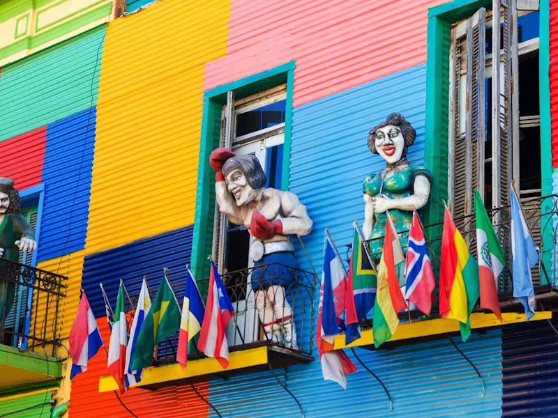 a-colorful-building-in-la-boca-neighborhood-of-buenos-aires-with-statues-and-flags