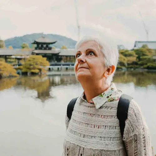 Tourist-in-the-temple-and-gardens-of-Kyoto-in-Japan-taking-pictures-with-her-phone