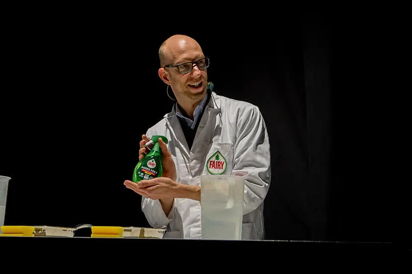 Científico de P&G mostrando en manos el nuevo Fairy Spray, utilizando una bata blanca con logo de Fairy