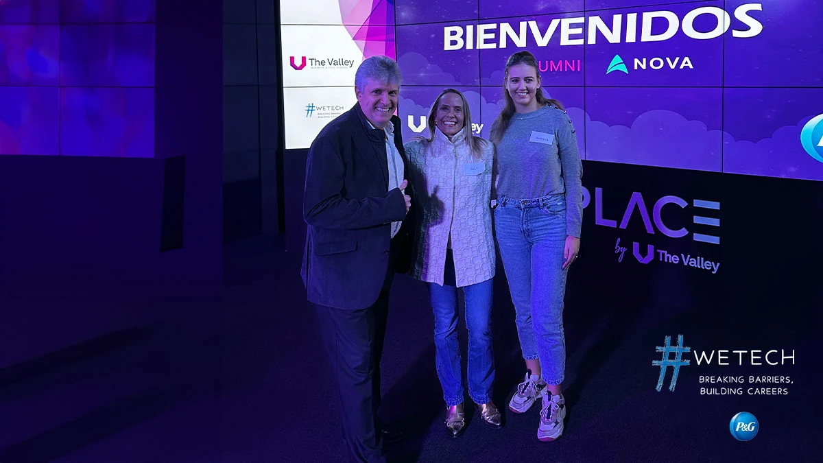 Un hombre y dos mujeres de pie y sonriendo hacia la cámara en el Evento Nosotros Tech