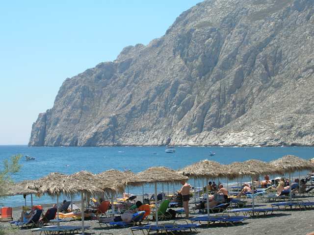 A view of a large mountain out to sea from Kamari beach, Santorini, Greece
