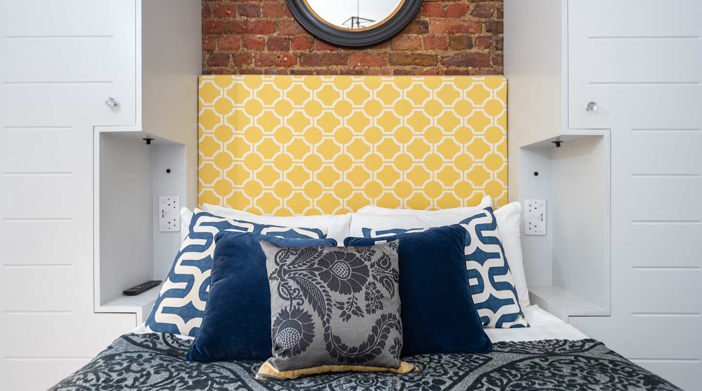 Pillows on the bed at The Yellow Baron, Plum Guide home in London