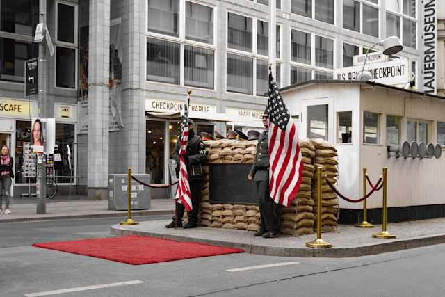 Guards holding USA flags at Checkpoint Charlie, Berlin, Germany
