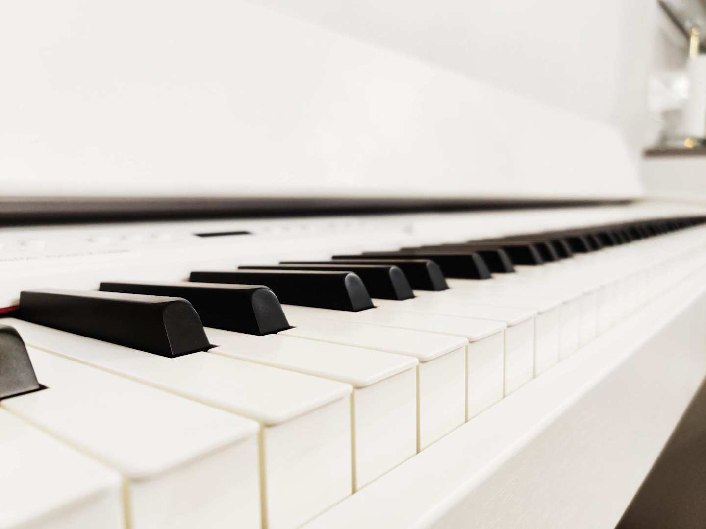 A close up view of piano keys on a white grand piano