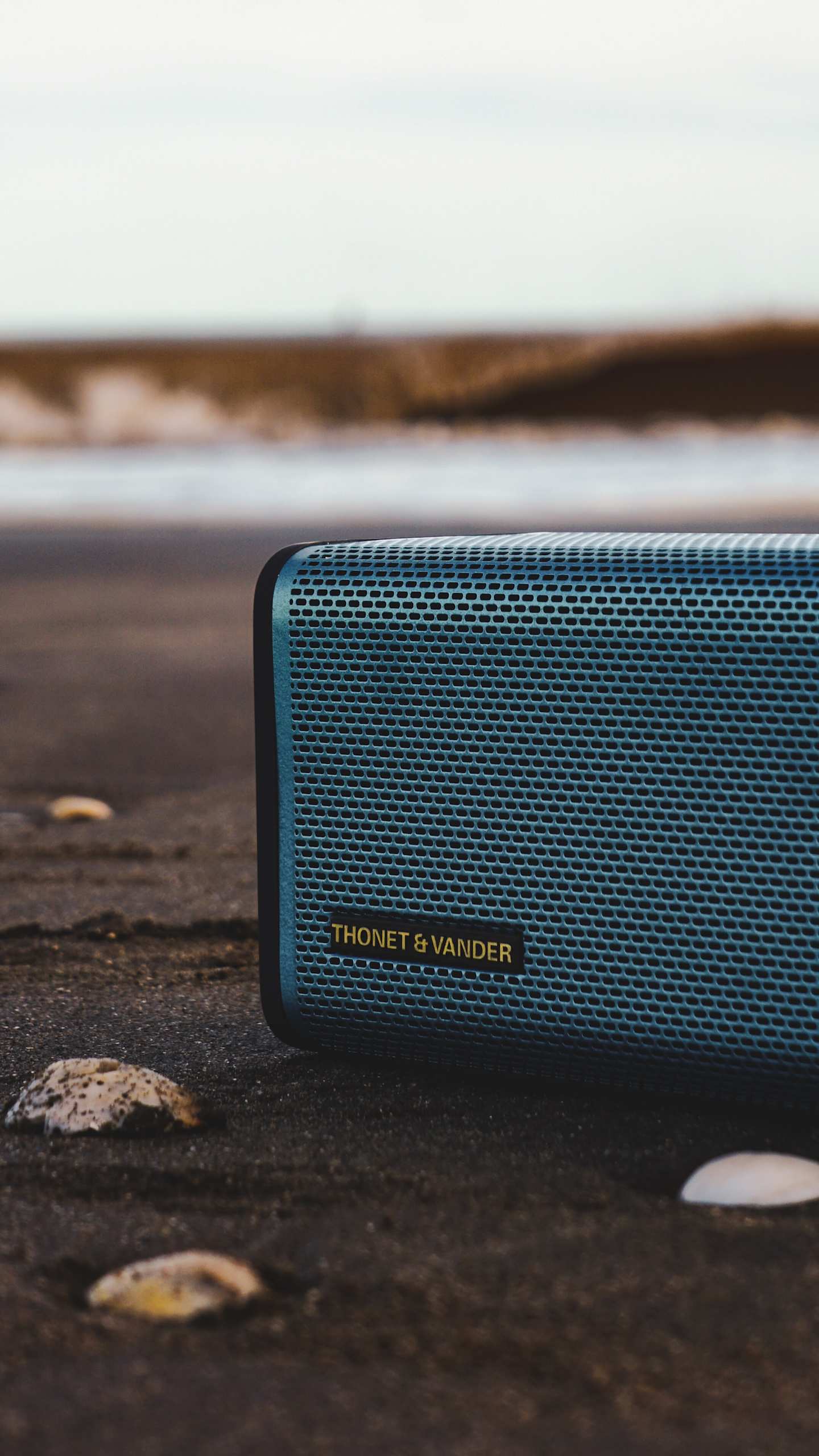 A close up of a blue portable speaker in an outside setting