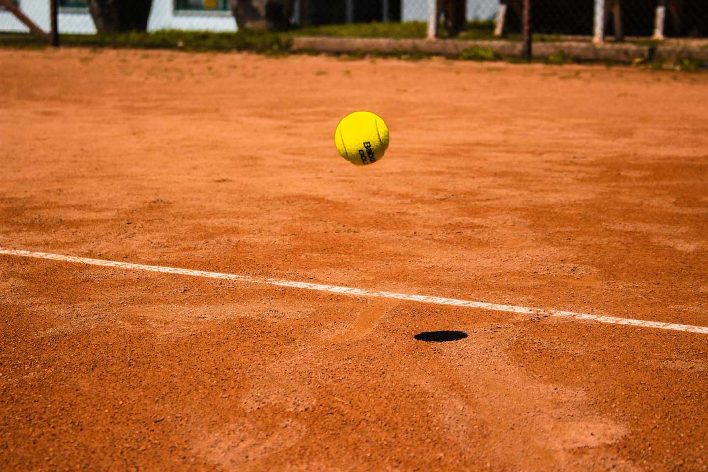 Tennis ball landing on a clay court
