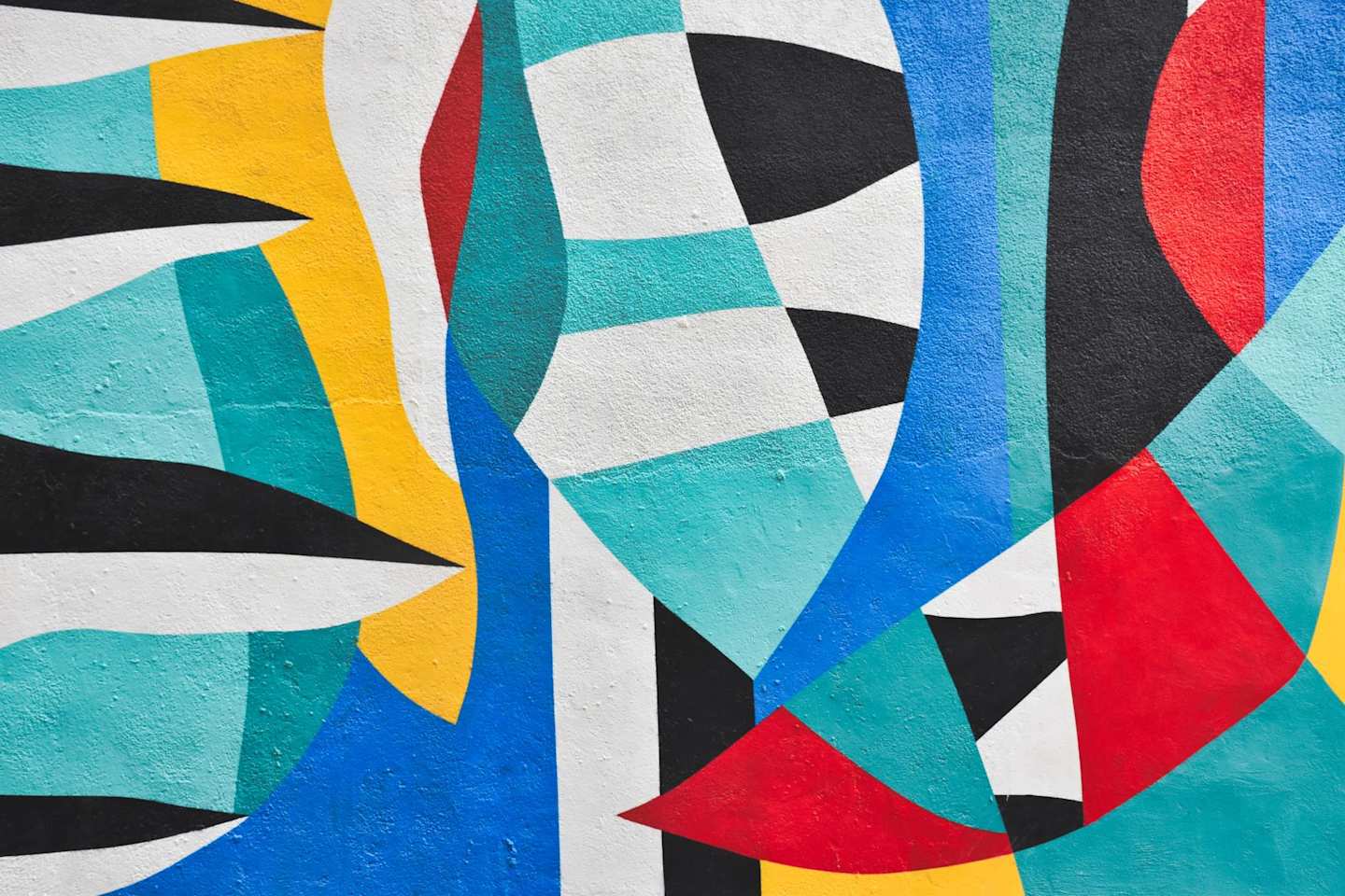 Blue, white, yellow, red and black paint in a piece of abstract street art