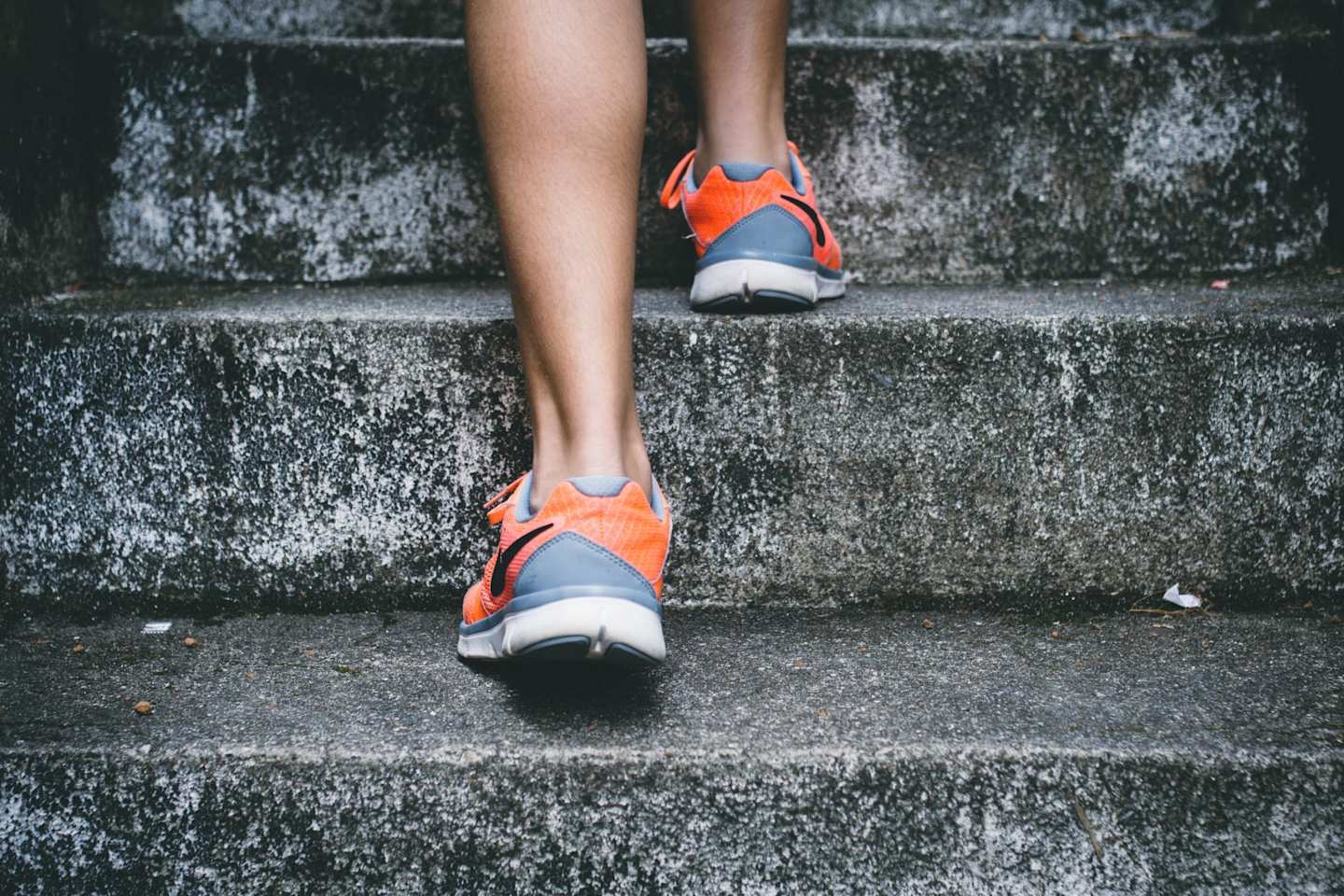 Close up on a person's running shoes as they climb steps