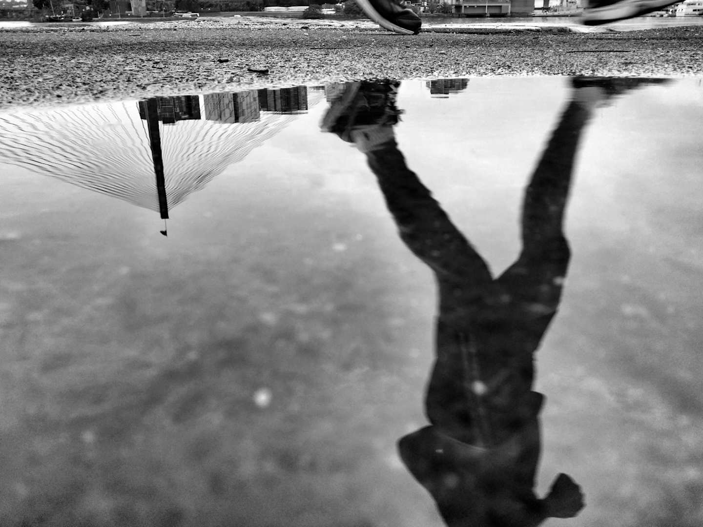 Greyscale reflection of a runner in a puddle