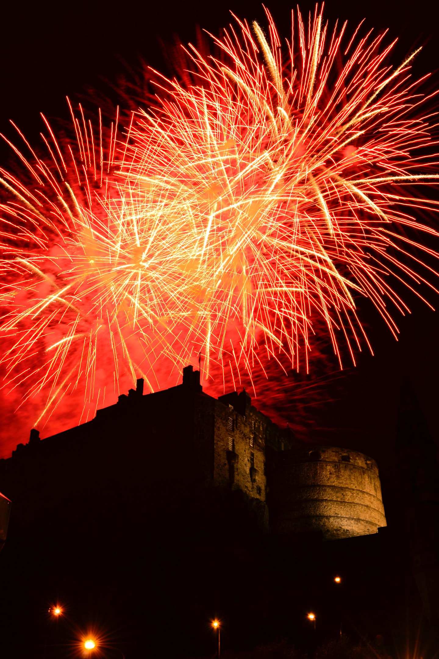 Red fireworks over Edinburgh Castle at night