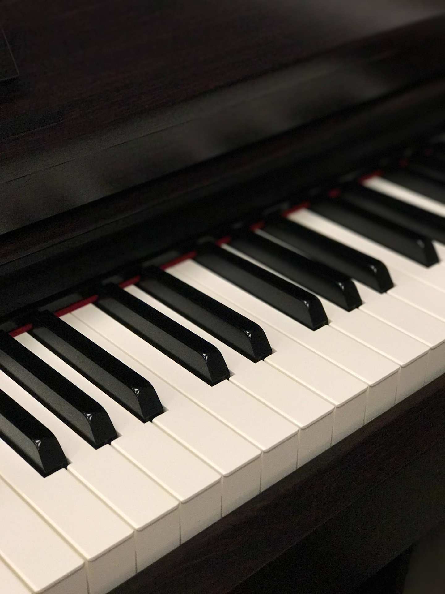 A close up view of the keys on a black grand piano