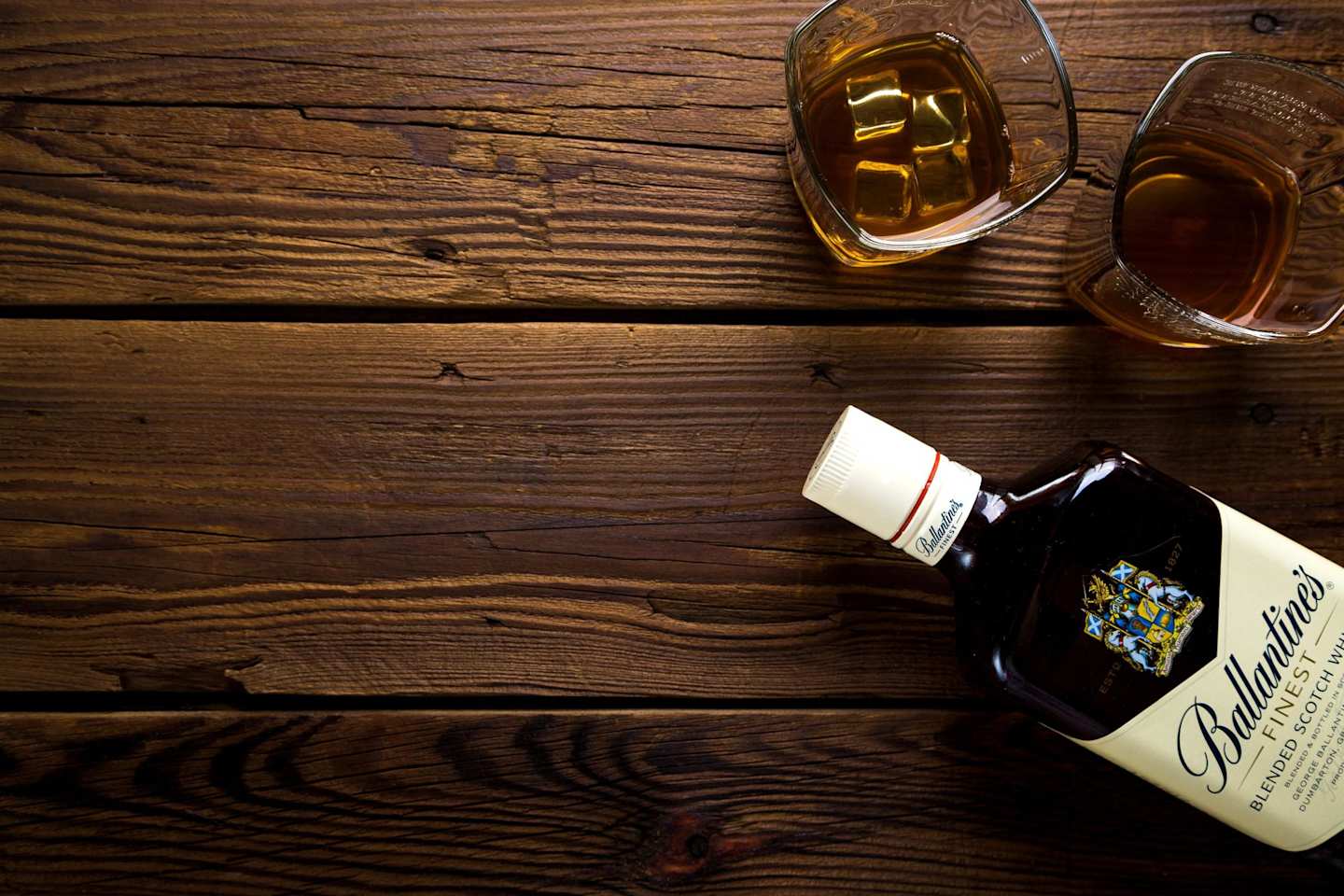A close up of a bottle of scotch whiskey next to two glasses on a table