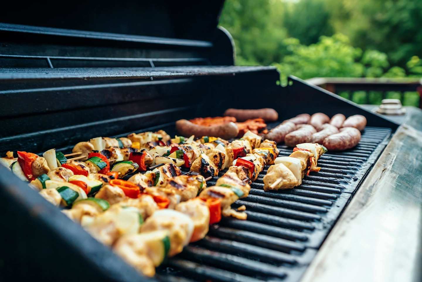 A close up of chicken and vegetable kebabs on a barbeque