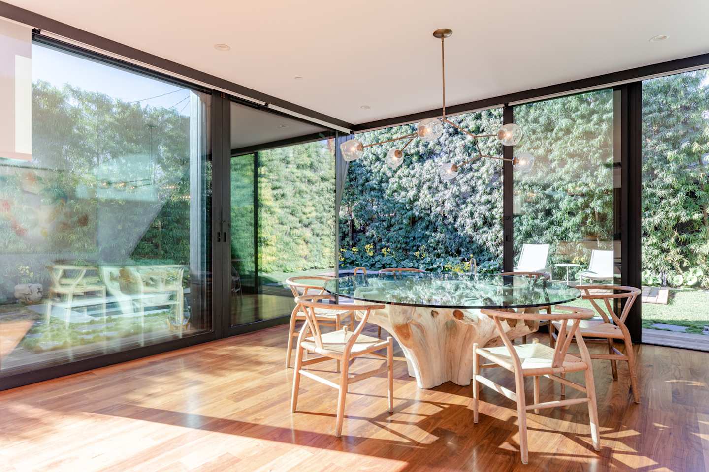Dining table with large windows at Bossa Nova, Plum Guide home in Los Angeles