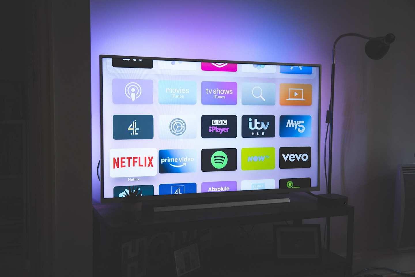 A television displaying a menu with Netflix in a dark room