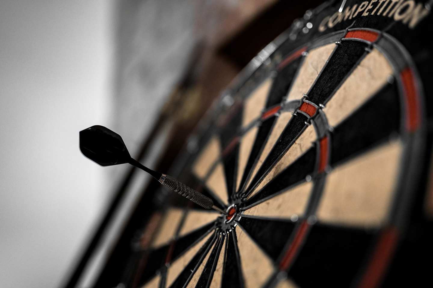 black dart on bullseye of black red and white dart board