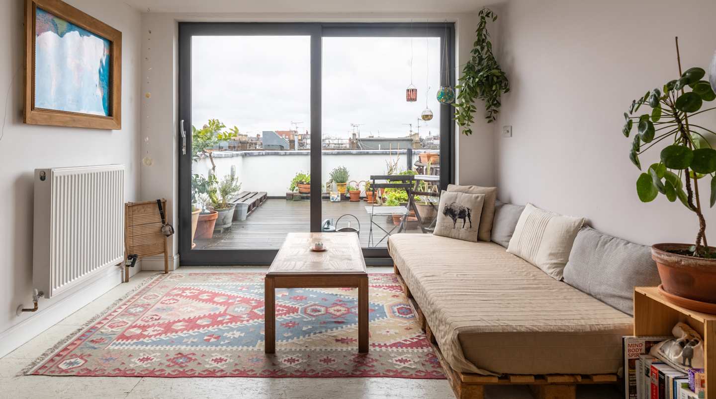 The living room looking onto the roof terrace where smoking is allowed at Vinyasa, Plum Guide home in London, UK