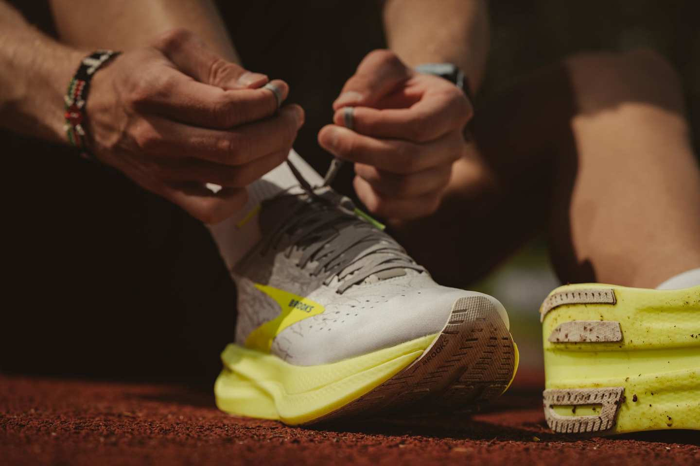 Person tying yellow and grey running shoe laces