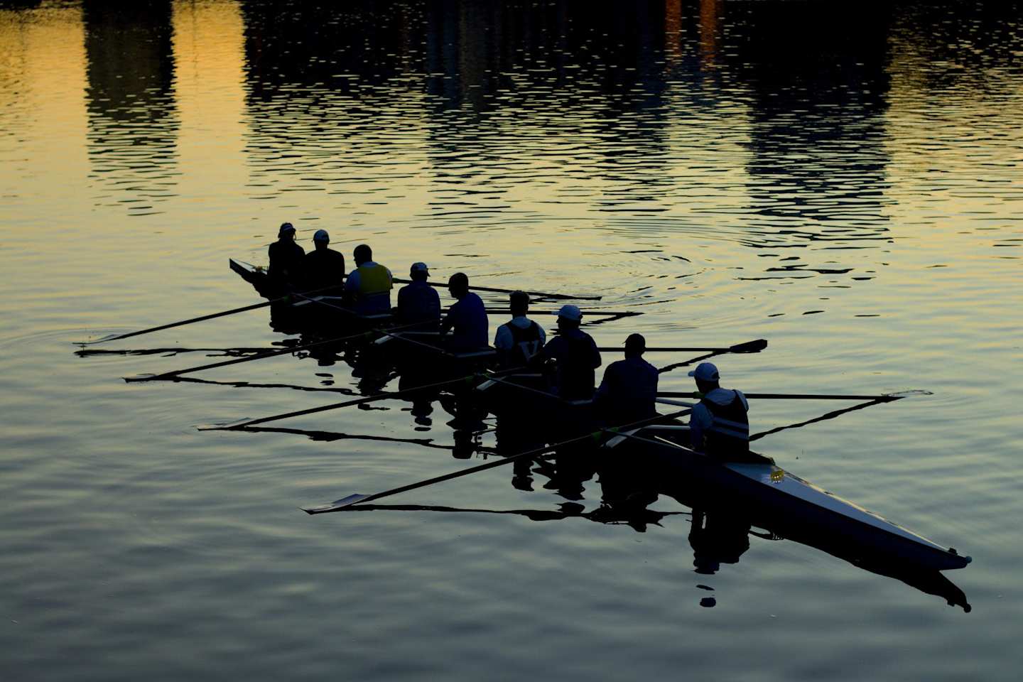 Rowing sports team in rowing boat on river in evening