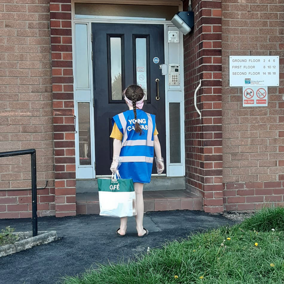 young girl stood at a front door delivering essential items to vulnerable people