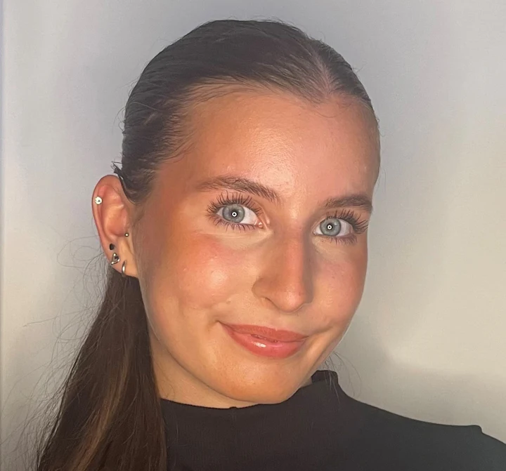 A photo of Grace, a young woman with long brown hair and blue eyes.