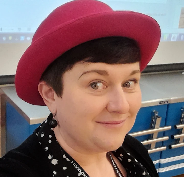 A woman smiling wearing a hat
