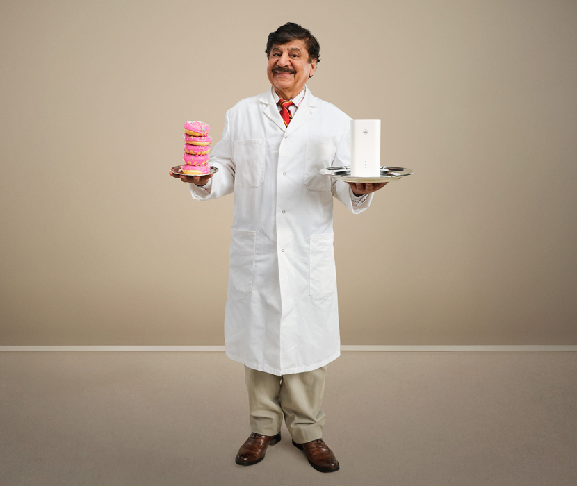 Karim i vit läkarrock som håller en router i handen