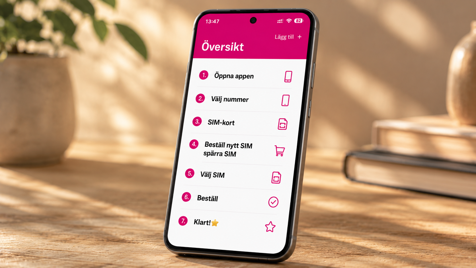 Bild på mobiltelefon som visar en Översikt i Comviq-appen på displayen. Numrerat från 1-7 hur man beställer ett nytt SIM-kort i appen. I bakgrunden syns två böcker och en kruka med en grön växt.