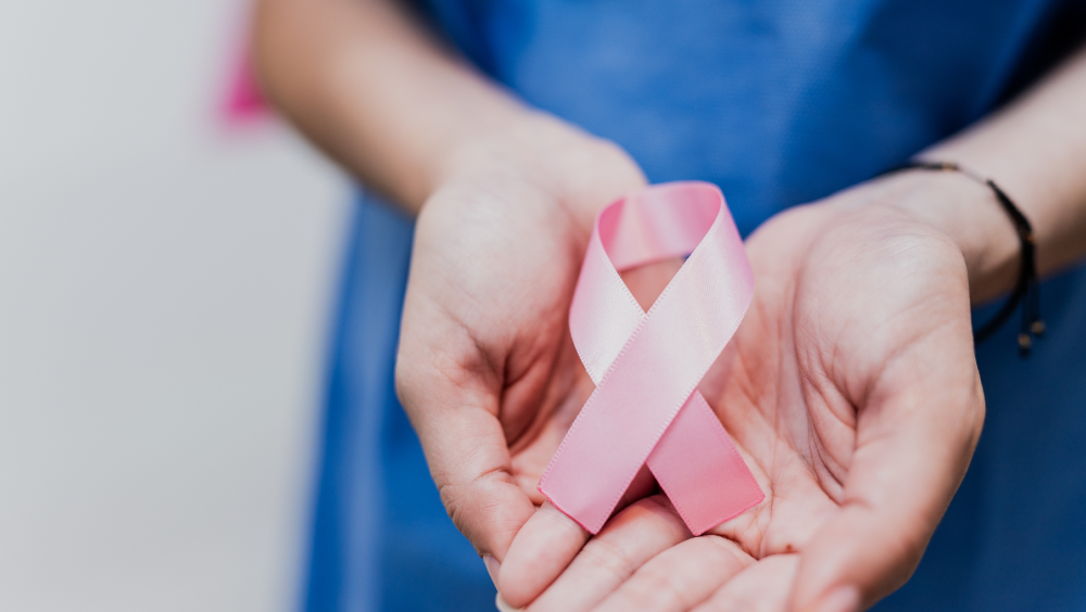 Cancer Prevention Tips A person holding a pink cancer ribbon in their hands