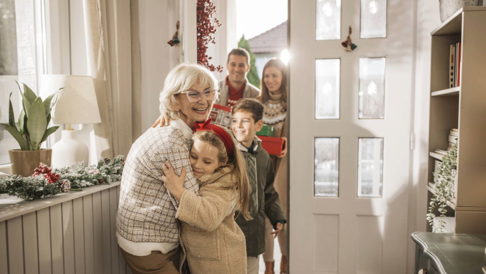Lean in this holiday season A grandmother hugging her granddaughter as the family enters her home